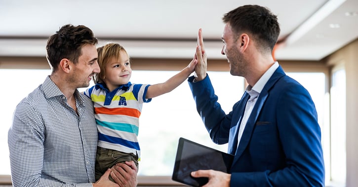 Real estate agent giving high-five to man's son