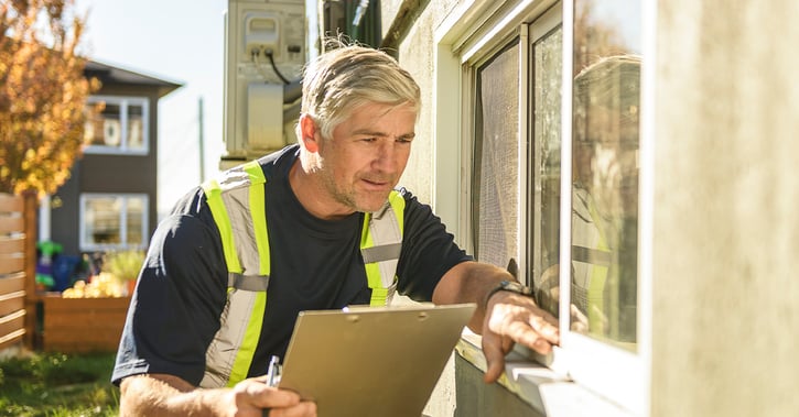 Man inspecting house window outside
