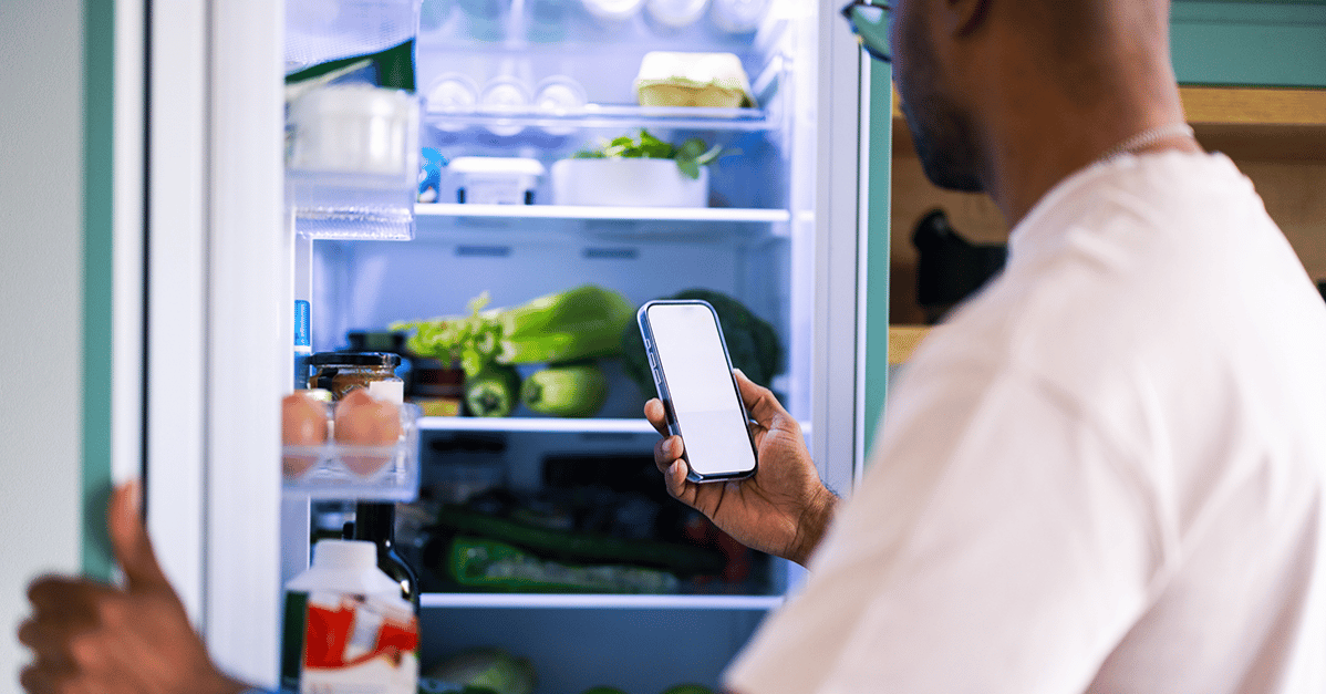 Man tracking fridge inventory on phone