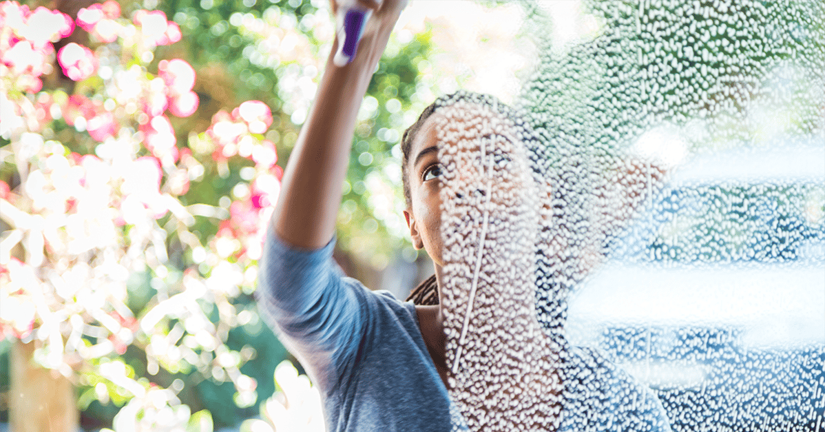 Young woman washing windows