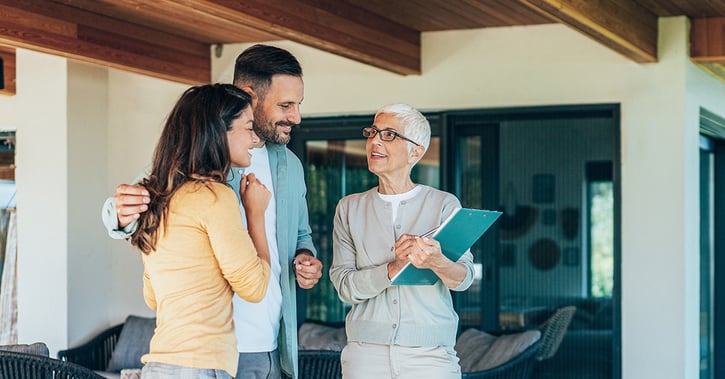 Real estate agent showing a house for sale to a couple_1200x628