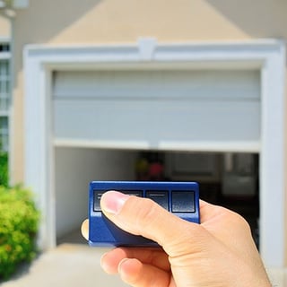 A man pressing the button on his automatic garage door opener.