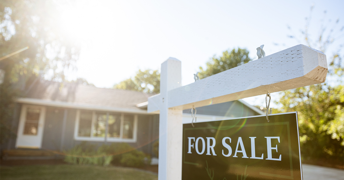 For sale sign posted in front of a residential home