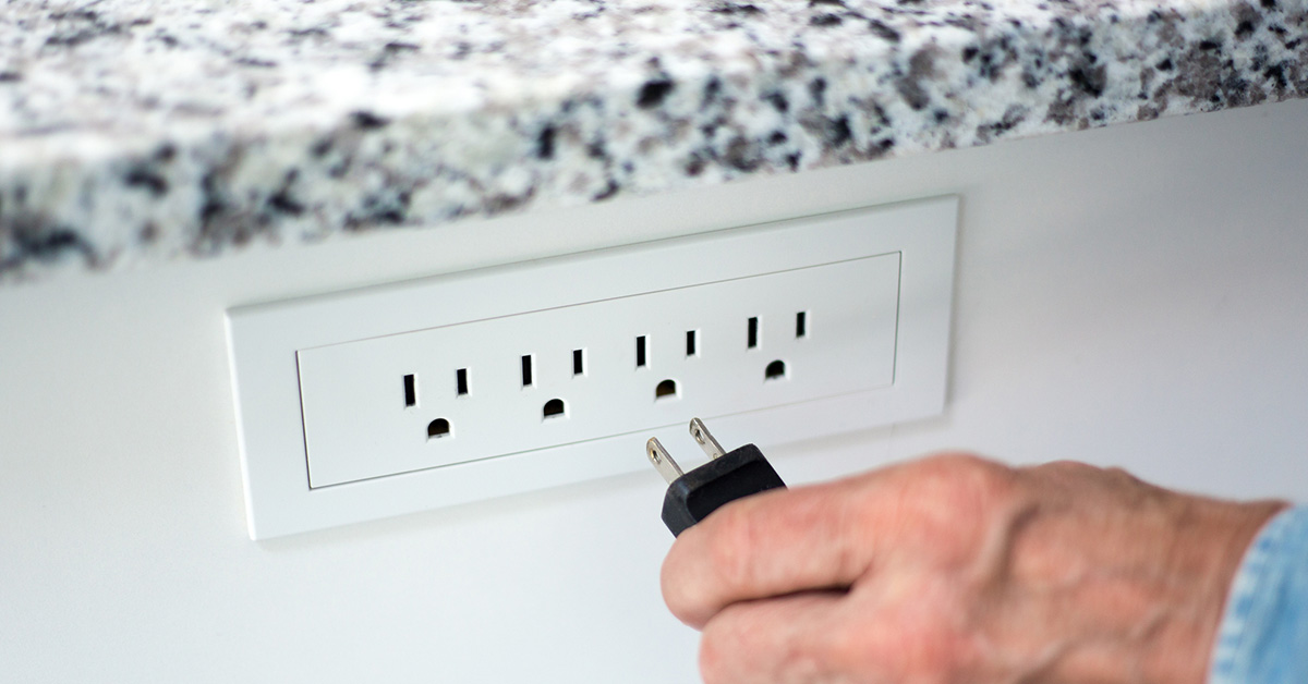 Plugging a power cord into an electrical outlet